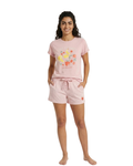 Woman wearing a pink pajama set with a white background