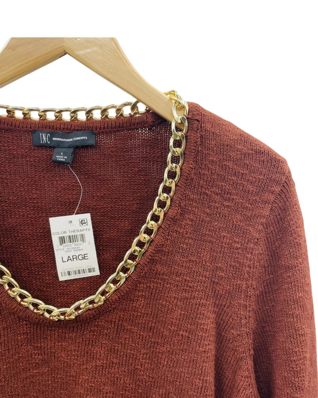 Brown sweater with gold chain detail on a hanger