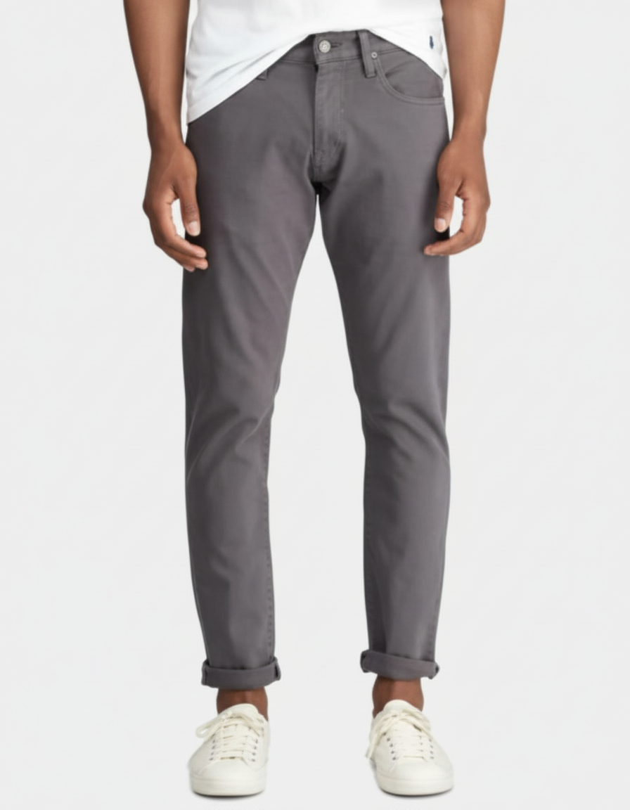 Person wearing gray pants and white sneakers on a white background