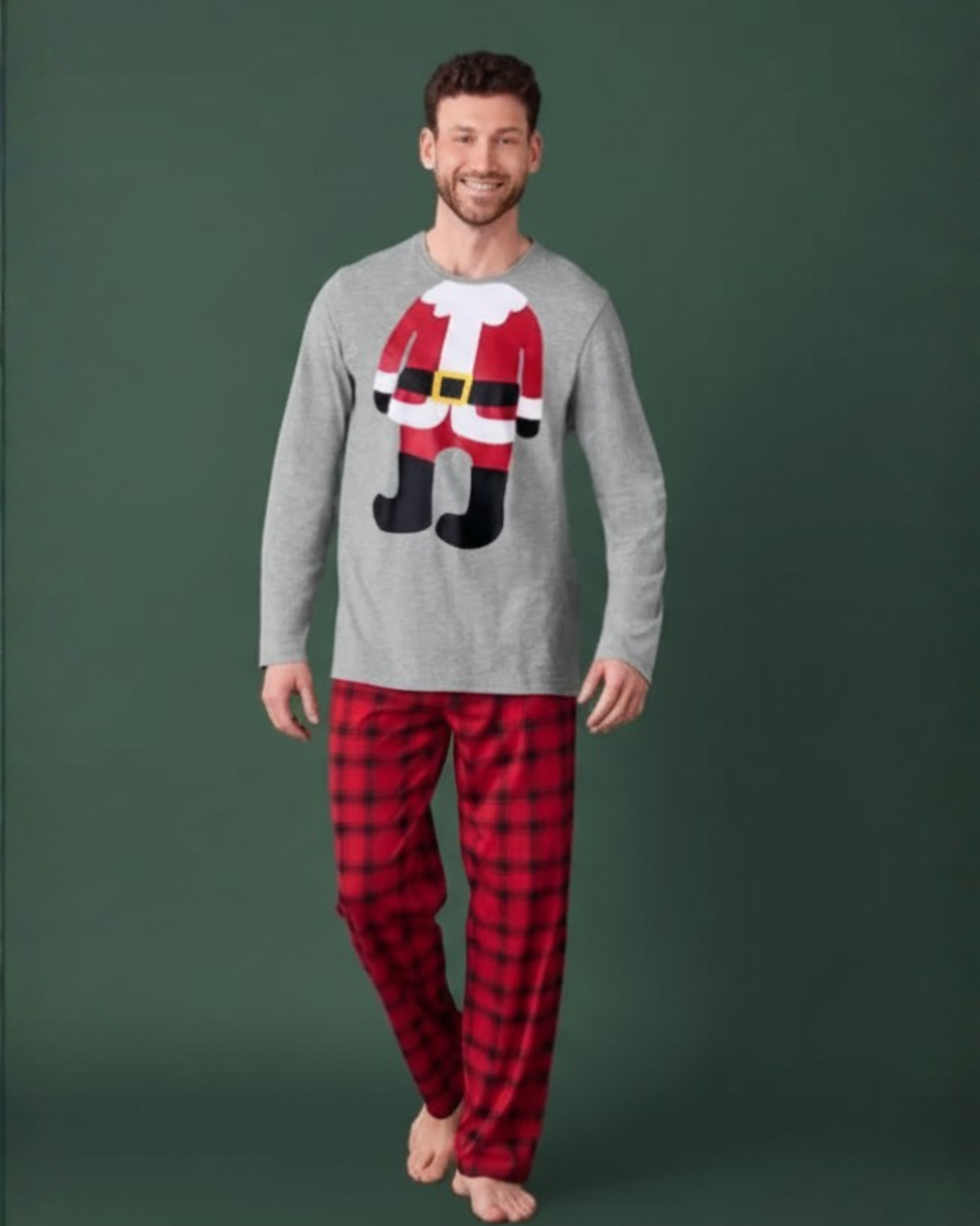 Man wearing a gray sweater with a Santa design and red plaid pants on a green background