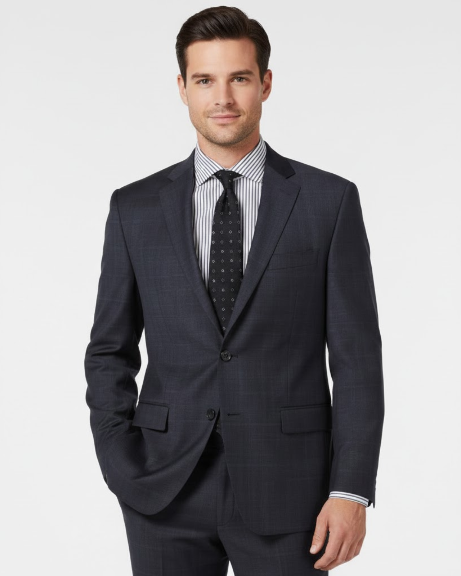 Man wearing a dark gray suit with a striped shirt and patterned tie on a light gray background