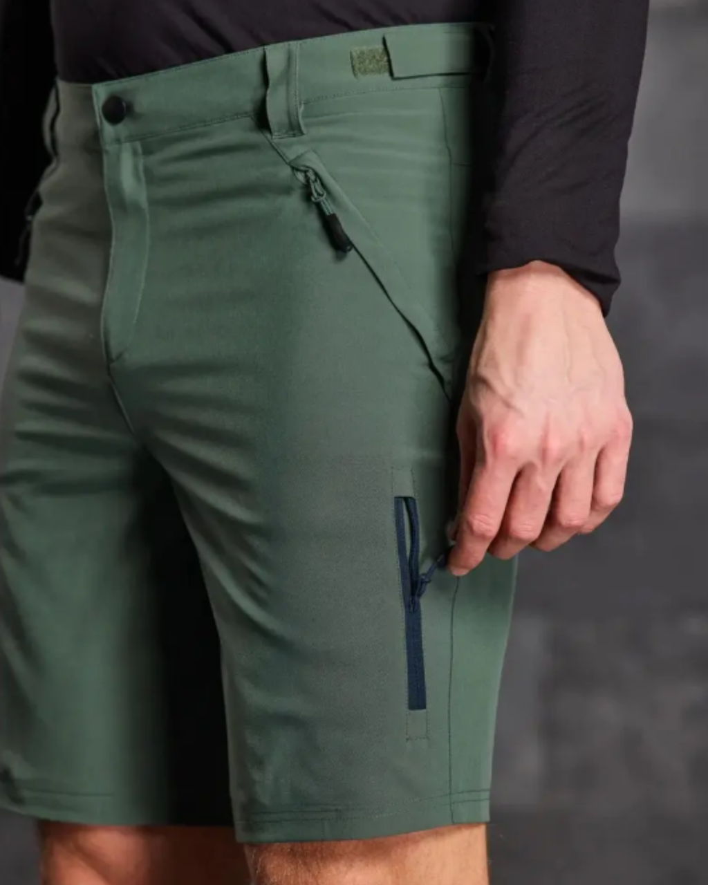 Green shorts with a zipper pocket on a gray background