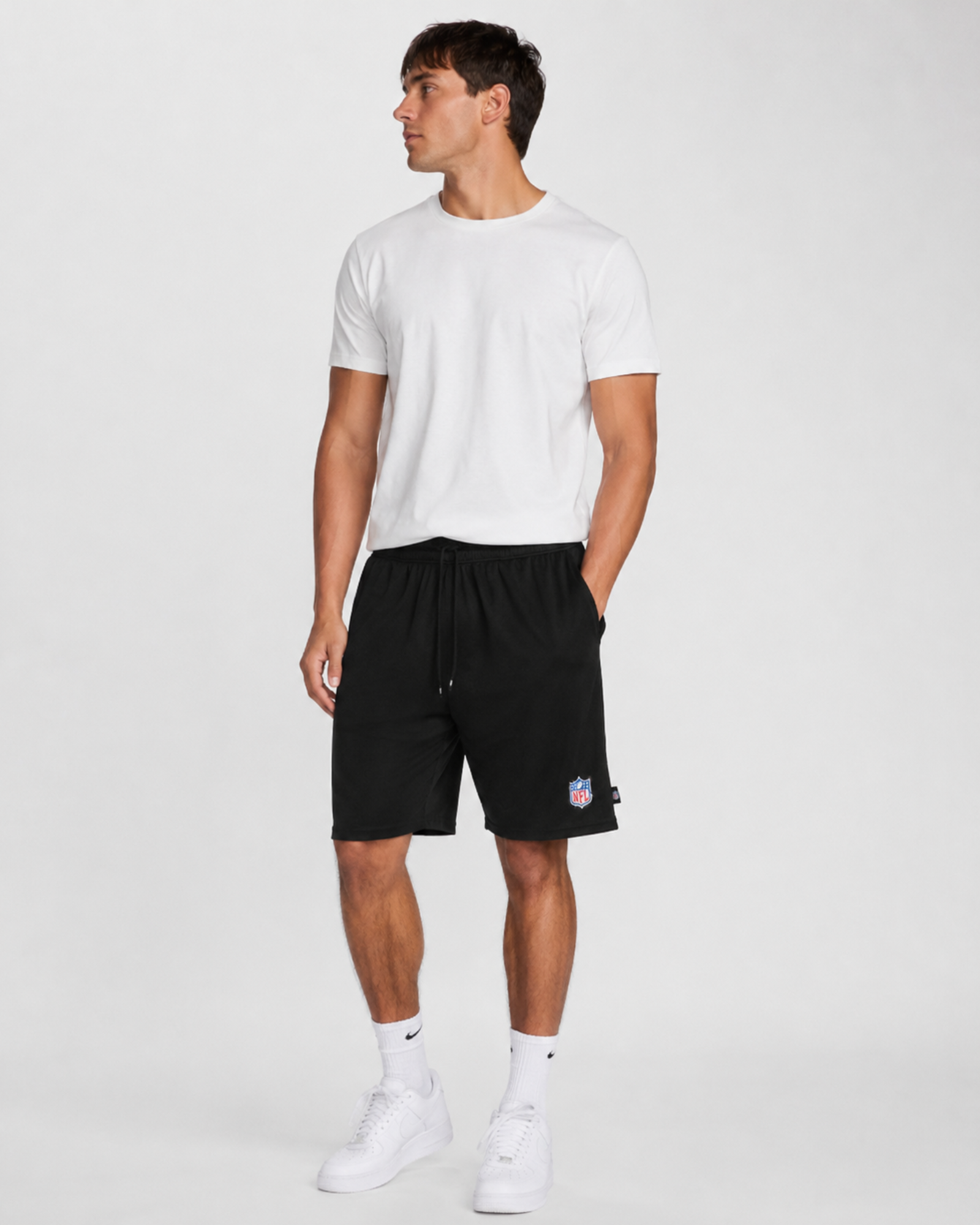 A man wearing white basic top with regular fit black short
