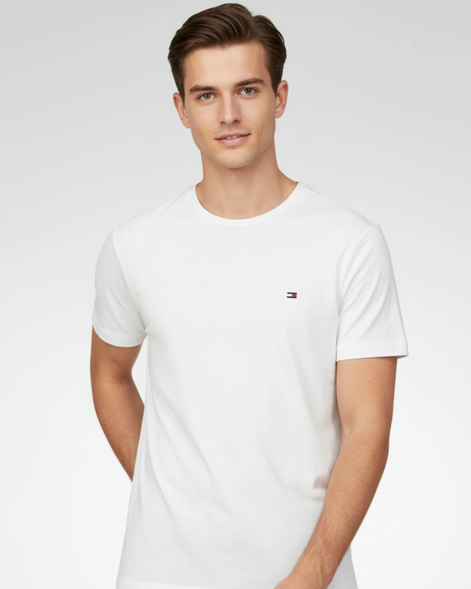 Man wearing a white t-shirt with a small logo on a light gray background