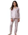 Woman wearing a pink floral pajama set on a white background