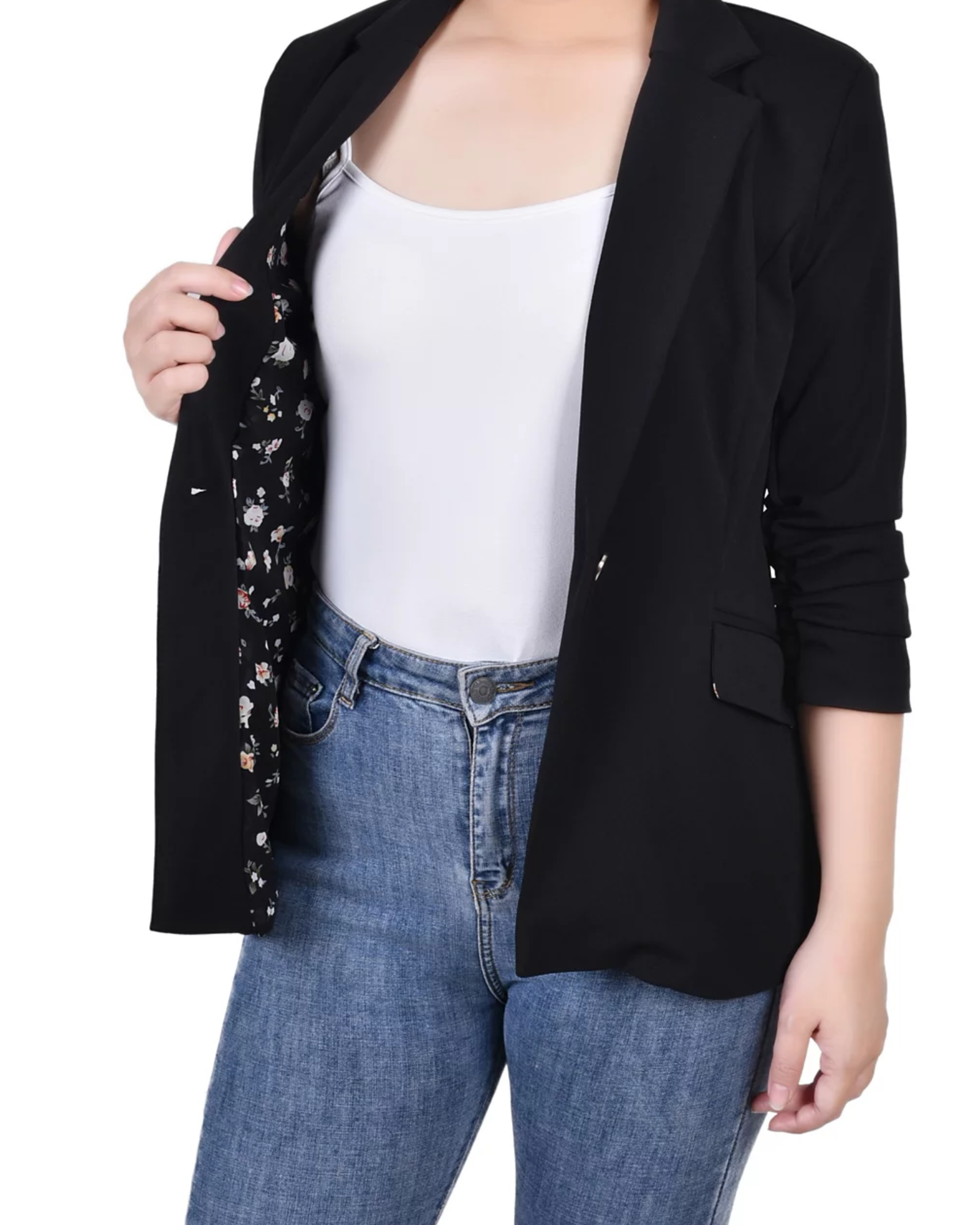 Woman wearing a black blazer over a white top and black pants on a white background
