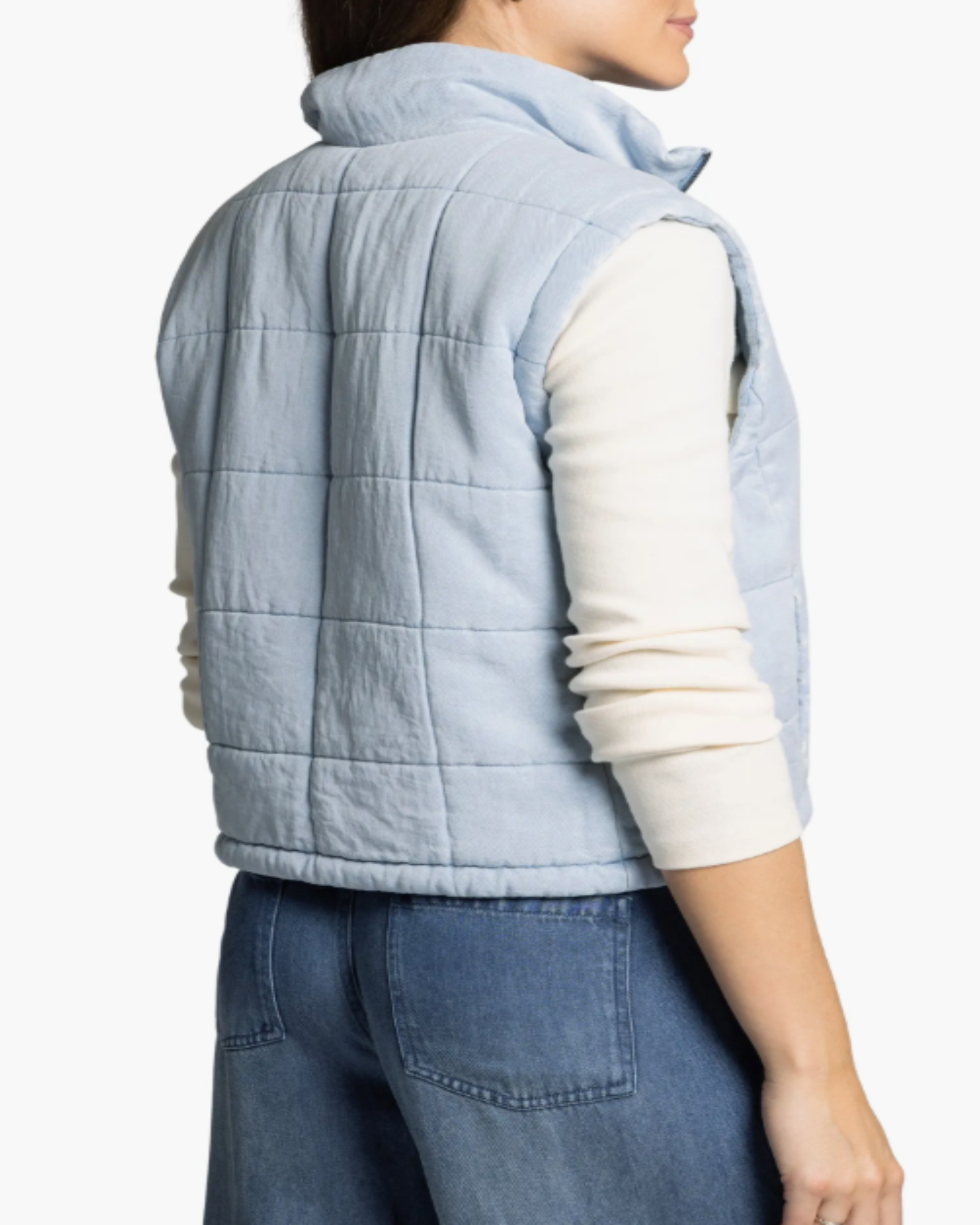 Light blue quilted vest worn by a women on a white background