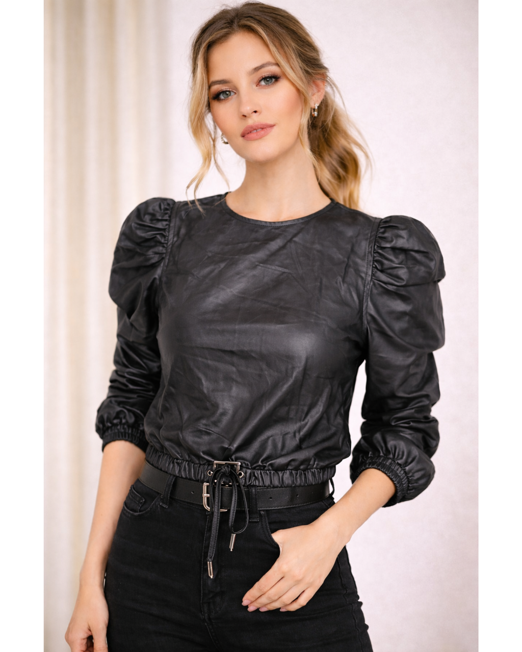 Woman wearing a black leather blouse with puffed sleeves 