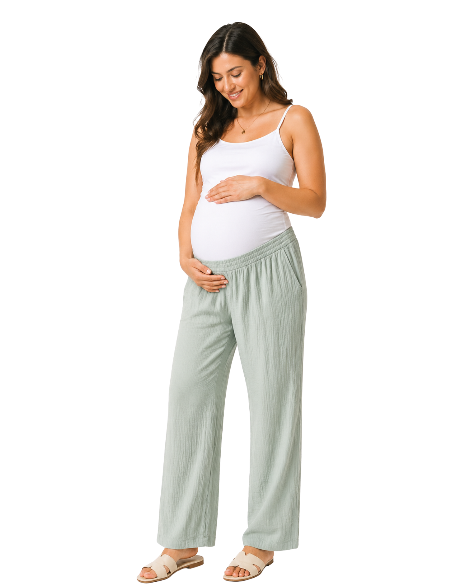 Pregnant woman wearing a white top and light green pants on a white background
