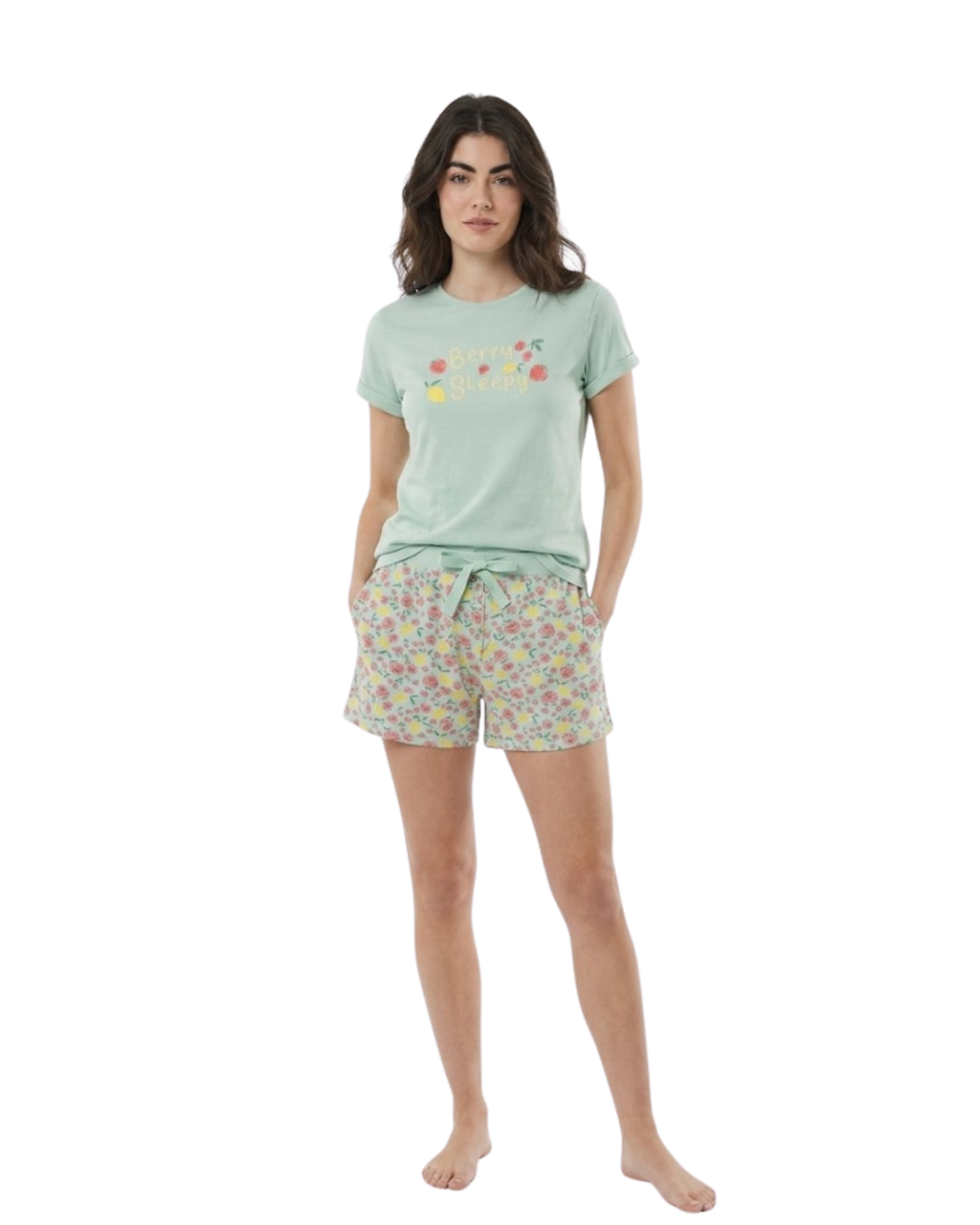 Woman wearing a light green t-shirt and floral shorts on a white background
