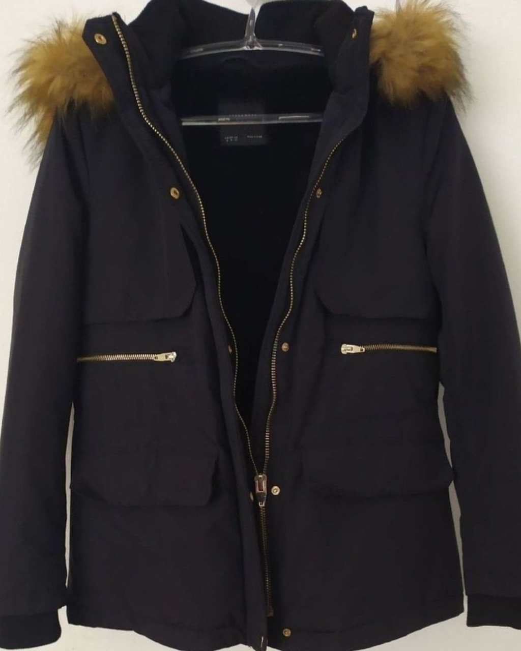 Black parka with gold zippers and fur-lined hood 