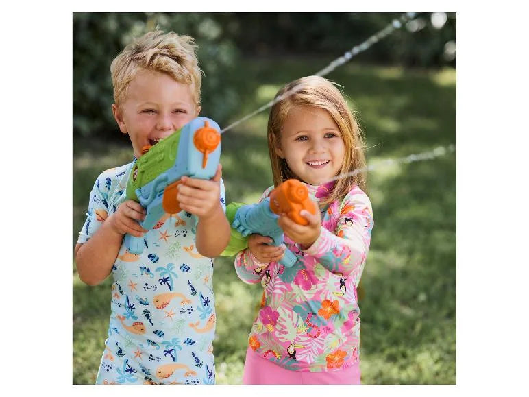 Two children holding toy guns outdoors with a grassy background