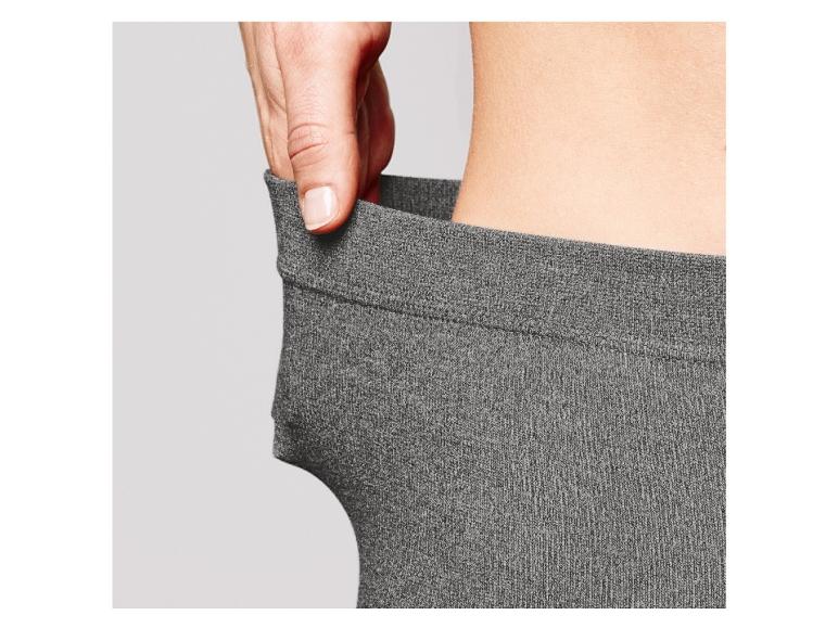 Gray leggings being pulled up to show fit on a plain background