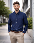 Man wearing a blue shirt and beige pants standing on a city street.