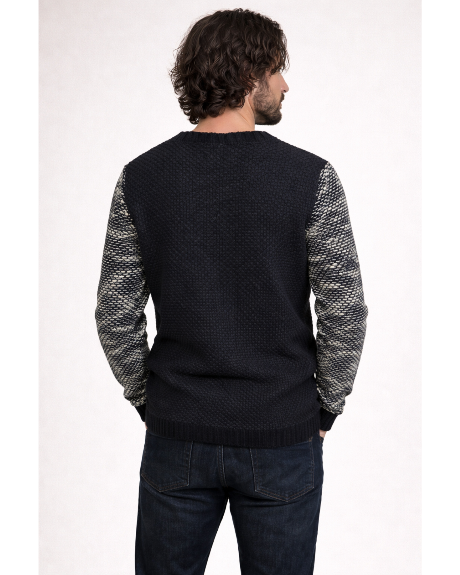 Man wearing a black sweater with patterned sleeves on a white background