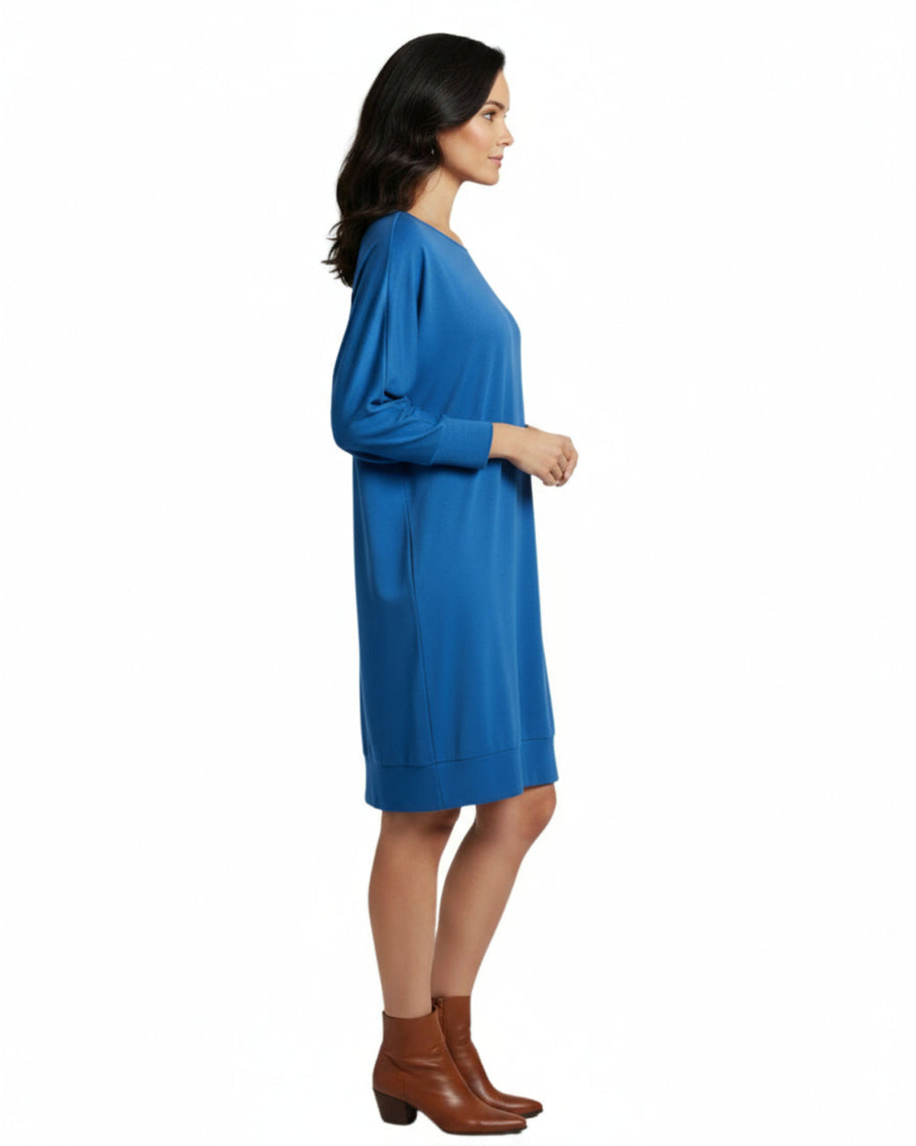Woman wearing a blue dress with brown boots on a white background