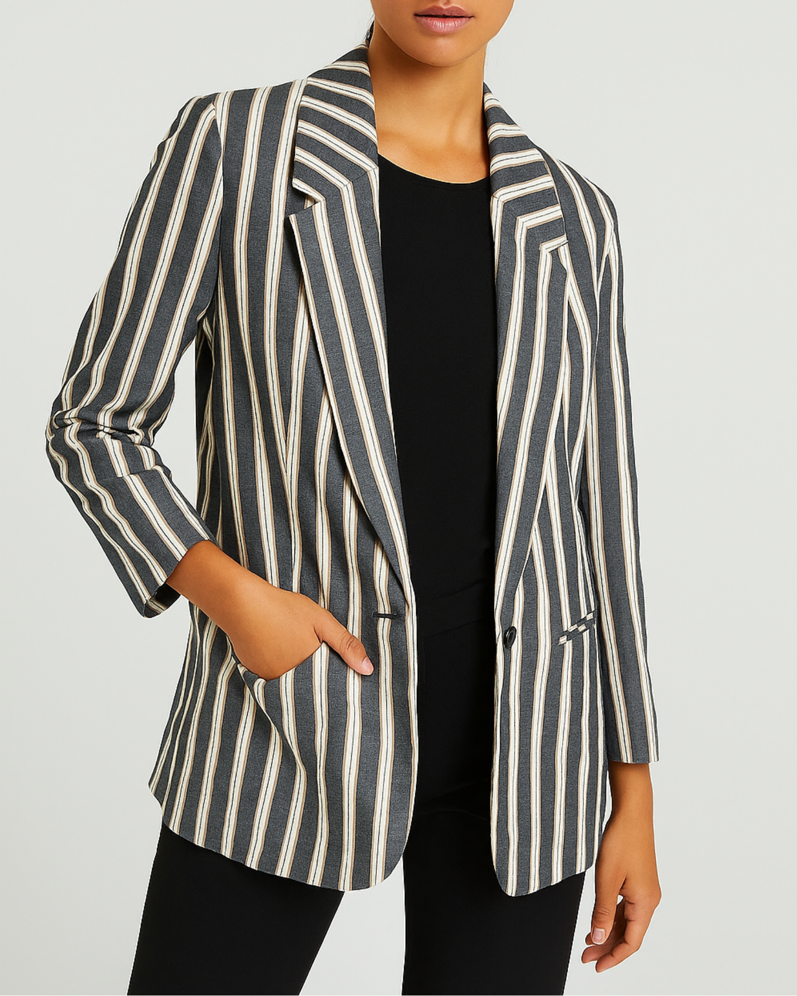 Woman wearing a striped blazer on a plain background