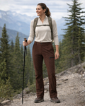 Woman hiking in a mountainous area with trees and mountains in the background