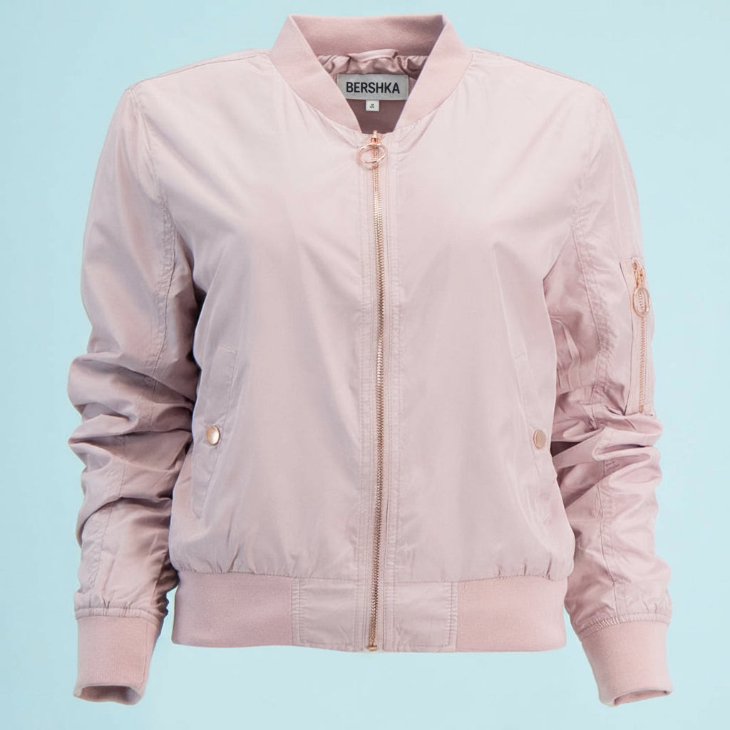 Pink bomber jacket with gold zippers on a light blue background
