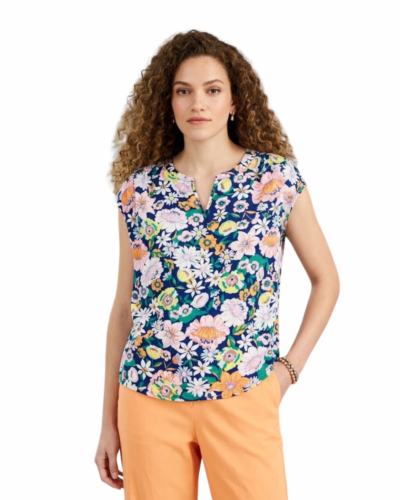 Woman wearing a colorful floral top and orange pants on a white background