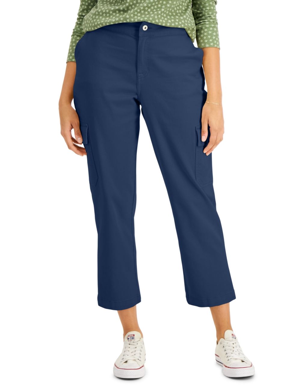 Person wearing blue pants and a green patterned top on a white background