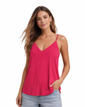 Woman wearing a pink tank top and jeans on a white background